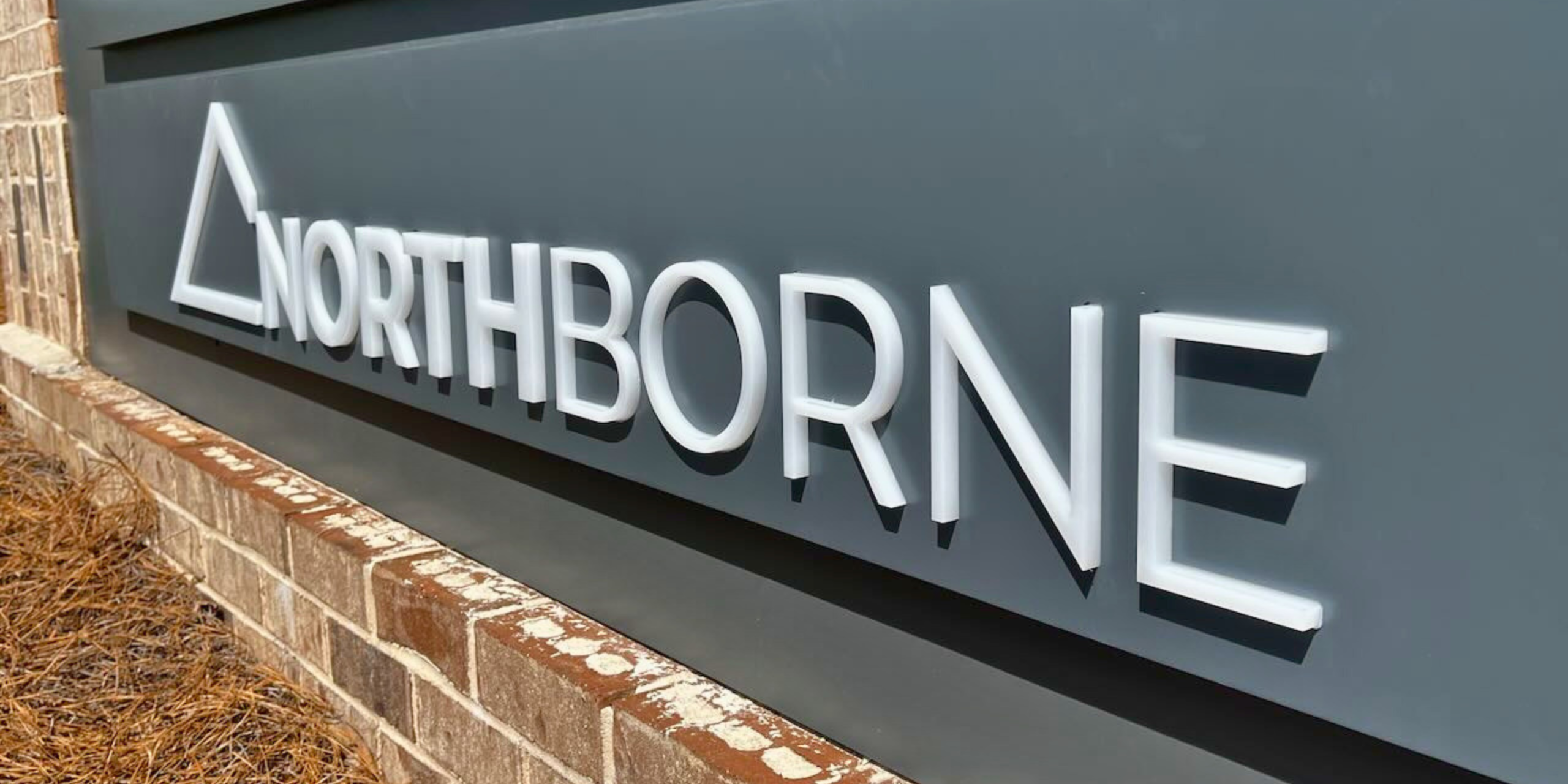 White dimensional lettering spelling “Northborne” mounted on a dark monument sign panel, creating a clean, modern exterior business sign with depth and shadow.